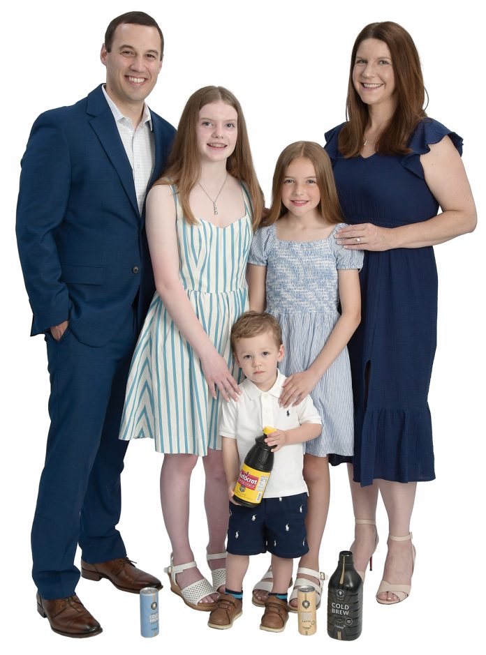 the propS Arthur Lopez poses with his wife, Heidi; daughters Kylie, 12, and Sophie, 10; and son, Caden, 2; and samples of Autocrat Coffee Syrup and tea products made at Finlay Extracts & Ingredients USA Inc.