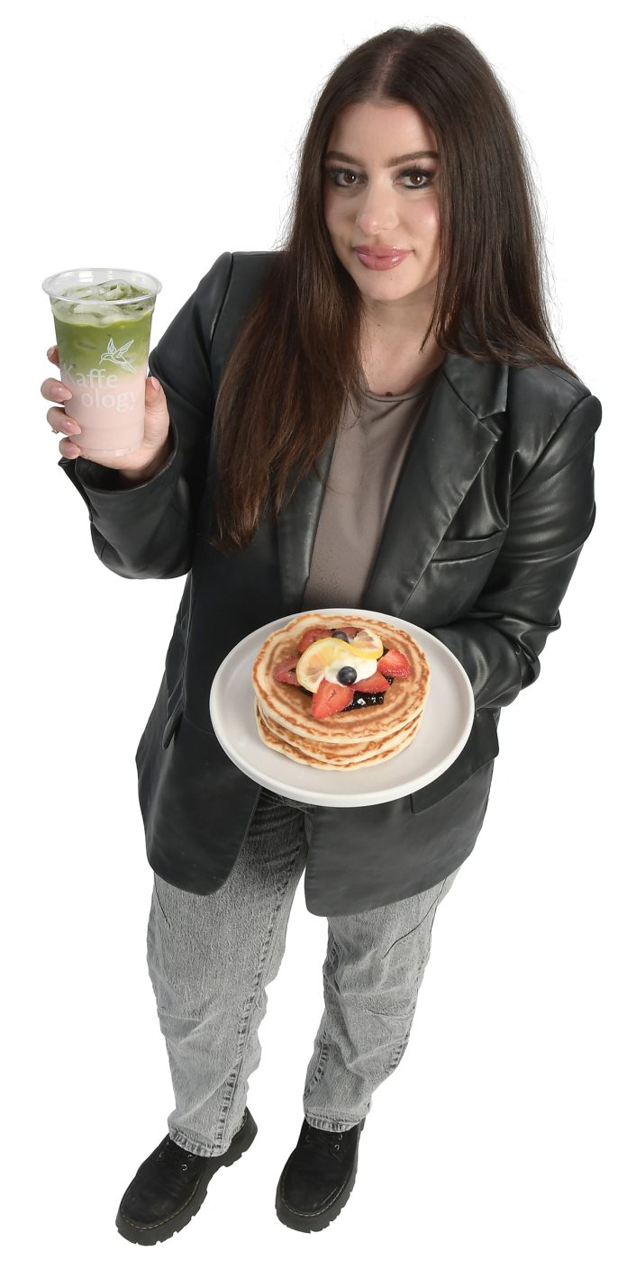 the prop Andreea Marin holds a branded cup and a dish on Kaffeology’s menu. “I want to bring our coffee because that is where it all started, a coffee shop in Newport,” she said.