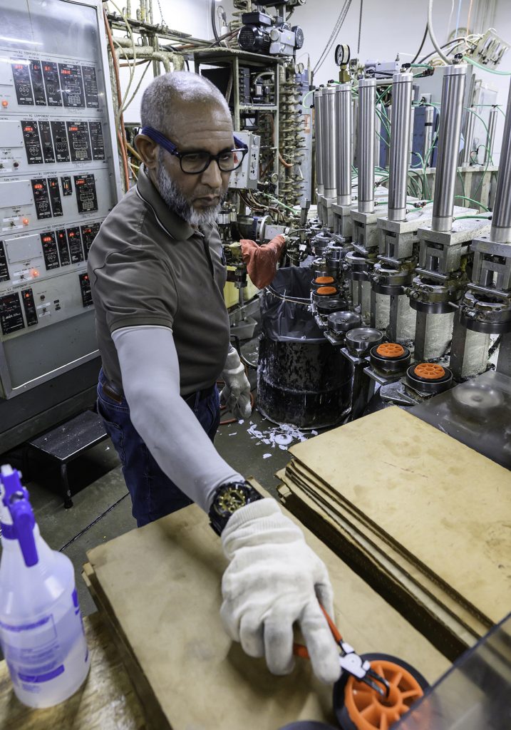 HUB OF ACTIVITY: Pedro Martinez, machine operator at Mearthane Products Corp., loads one of the wheel-molding machines at the Cranston factory.  PBN PHOTO/MICHAEL SALERNO