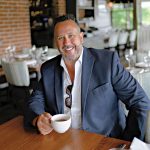 GOOD TIMES: Corey Barreira, the director of operations at the Newport Restaurant Group, in the dining room at the Waterman Grille in Providence. Despite challenges, Barreira says, the summer has been profitable for the employee-owned restaurant company.  PBN PHOTO/MICHAEL SALERNO
