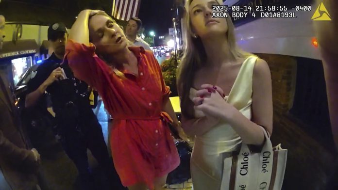 IN AN IMAGE taken from police body camera footage, Newport Police officers interacting with R.I. Special Assistant Attorney General Devon Flanagan, left, and her friend outside the Clarke Cooke House in Newport on Aug. 14. /NEWPORT POLICE DEPARTMENT VIA THE ASSOCIATED PRESS
