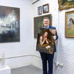 OPEN FOR BIDS: Vallots Auctioneers founder Michael Dym with some of the art to be auctioned at his auction house in Providence. Dym started the business in New York City in 2003 but moved it to Providence in 2021.  PBN PHOTO/MICHAEL SALERNO 