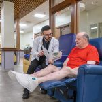 Air quality in R.I. a problem that just won’t blow over QUALITY CONCERNS: Curtis Dyer, left, clinical pharmacy operations manager at PACE Organization of Rhode Island, speaks with PACE participant Mark Harter about his medications. With a greater number of air quality alerts in recent years, officials at PACE are worried about the effects on the elderly.
PBN PHOTO/MICHAEL SALERNO