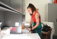 PAPERWORK: Rivka Reynolds, a peer recovery counselor with Thrive Behavioral Health Inc., fills out some paperwork in her organization’s West Warwick office. PBN PHOTO/PAUL SPETRINI