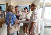 CHECKING IN:  Bella Andolino, background right, front desk agent at Hotel Maria in Westerly, with General Manager Patrick Bowe at her side, helps Skip and Pat Caloia of Yonkers, N.Y. PBN PHOTO/ MICHAEL SALERNO