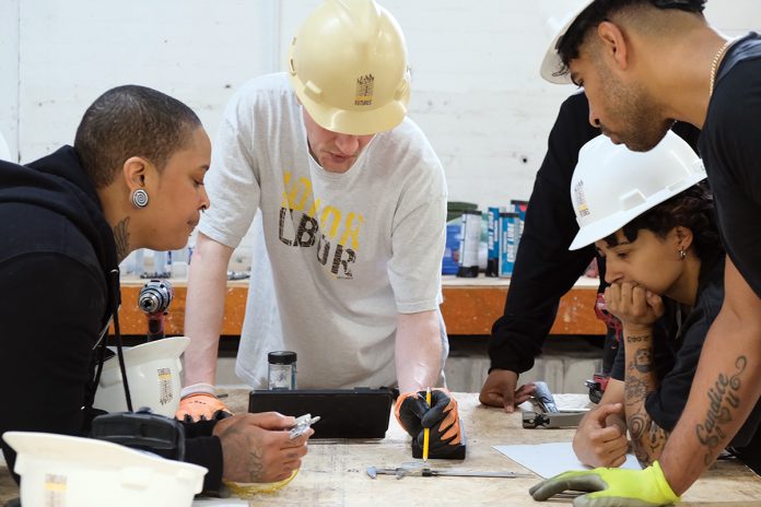 TRAINING: Quiana Ferguson, left, and Glendale Perez, center, students in a Building Futures pre-apprenticeship class that was held earlier this year from May 5 to June 6, work with Building Futures training team instructor Brook Swanson, second from right, on an exercise designed to introduce techniques used by millwrights. Pictured at right foreground is an unidentified student. COURTESY BUILDING FUTURES