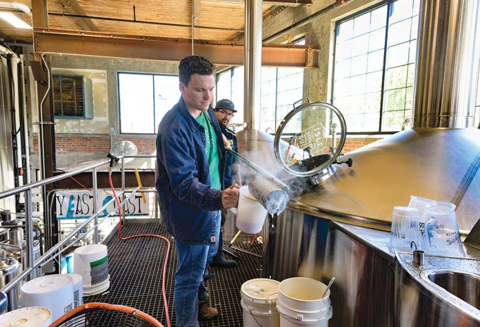 GLASS HALF FULL? A softening market has many local craft beer makers looking for new products and customers. Pictured is brewer Matt Von Holten, foreground, and cellarman Eric Gonzalez, at The Guild Brewery in Pawtucket.  PBN FILE PHOTO/MICHAEL SALERNO
