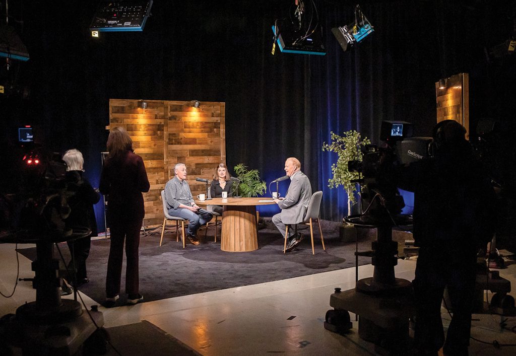 MELDING MEDIA: Jim Hummel, right, hosts a taping of the public affairs TV show “A Lively Experiment” with guest journalists Ted Nesi, left, and Nancy Lavin. The studio is part of Ocean State Media, the entity formed from the merger of Rhode Island PBS and The Public’s Radio merged in 2024.  PBN PHOTO/TRACY JENKINS