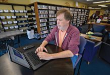 WORK ­ENVIRONMENT: Independent journalist Steve Ahlquist taps out a story on his laptop at the ­Rochambeau Library in Providence. He’s covered social issues for a few small local blogs and now publishes on the digital platform Substack.  PBN PHOTO/ MICHAEL SALERNO