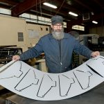 Renova Lighting Systems prioritizes sustainable and American-made lighting fixtures SHINING BRIGHT: Richard Reynolds, fabrication supervisor at Renova Lighting Systems in Warwick, holds a sheet of protective coating for light fixtures.
PBN PHOTO/ELIZABETH GRAHAM