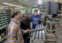 Tradition and technology make for a potent combination at Hawkins TEAM EFFORT: Troy Hawkins, left, and CJ Hawkins, center, both machinists, and Russell Walsh, shop manager, work on the manufacturing floor at Hawkins Machine Co. in Coventry.
PBN PHOTO/
ELIZABETH GRAHAM