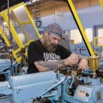 Groov-Pin prioritizes employee wellness to increase efficiency ATTENTION TO DETAIL:
Ray Scungio, Escomatic supervisor, works on an Escomatic screw machine at Smithfield-based Groov-Pin Corp., which produces fasteners, grooved pins and Tap-Lok threaded inserts that are used in the automotive, aerospace and die casting industries.
PBN PHOTO/TRACY JENKINS