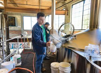 TESTING: Brewer Matt Von ­Holten, foreground, and cellarman Eric Gonzalez, who oversees the day-to-day post-brewing processes, test the wort – the liquid ­extracted from the mashing process when brewing beer – at The Guild Brewery in Pawtucket. PBN PHOTO/MICHAEL SALERNO