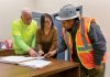GAME ­PLANNING: Lori Manni, center, president of Capital City Construction & Management Services Inc., goes over documents with Al DeRobbio, left, project supervisor, and Oliver Carias, operating engineer of Local 57, at the company’s Cranston office. PBN PHOTO/­MICHAEL SALERNO