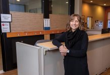 QUIET FOR THE MOMENT: Gretchen Anderson, senior clinical director of ambulatory and outpatient behavioral health at Butler Hospital, stands at the desk outside the hospital’s Express Care walk-in clinic, catering to people in need of immediate mental health services.  PBN PHOTO/TRACY JENKINS  