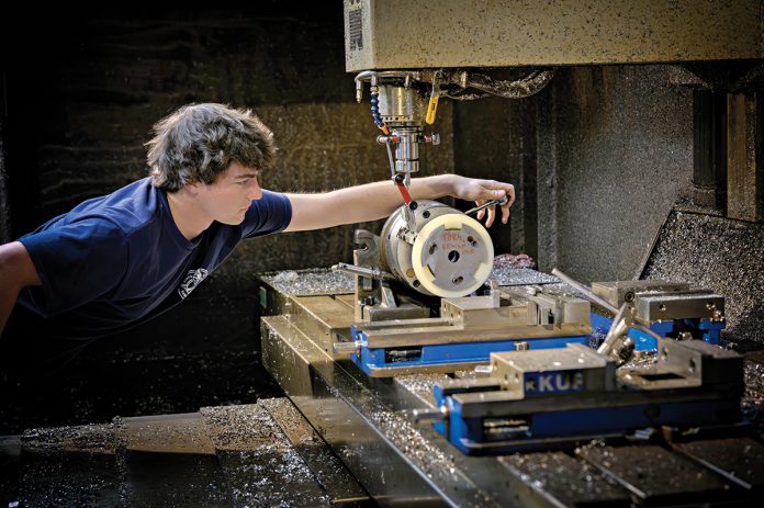 CAREFUL CRAFTING: Machinist Troy Hawkins takes a measurement while setting up the equipment at Hawkins Machine Co. in Coventry. Hawkins is the fourth generation of the family to work at the company, which is feeling the squeeze of rising costs.  PBN PHOTO/MICHAEL SALERNO