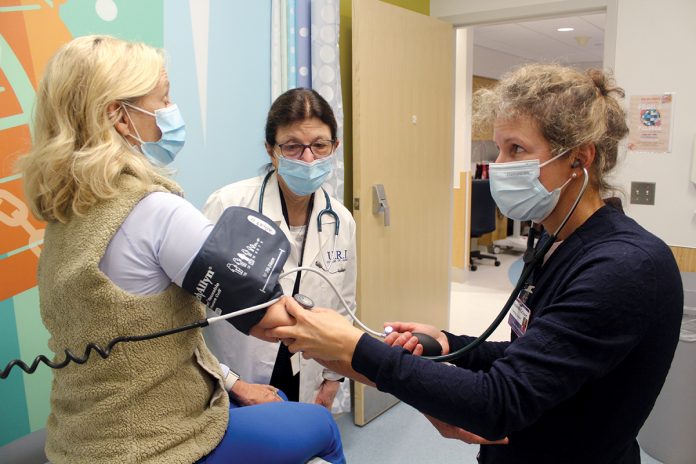 LEARNING ­OPPORTUNITY: Denise Coppa, center, University of Rhode Island College of Nursing professor and interim associate dean, supervises as nurse practitioner student Elizabeth Grieser, right, examines a patient at Rhode Island Hospital.  COURTESY ­UNIVERSITY OF RHODE ISLAND