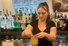 SPECIAL DRINK: Katie Hamilton, bartender at Fleur Providence in the Omni Providence Hotel, serves a mango lemon spritz made with lemonade infused with THC. The restaurant is one of a limited number of the locations in Rhode Island licensed to sell beverages containing hemp-derived THC, and consumer demand is growing, Hamilton said.  PBN PHOTO/­CHRISTOPHER ALLEN