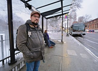 TIME CONSCIOUS: Barry Dejasu of East Providence waits at Kennedy Plaza to make his R.I. Public Transit Authority bus home after arriving on a bus from Warwick, where he works. RIPTA service changes have made his commute longer and more complex. PBN PHOTO/MICHAEL SALERNO