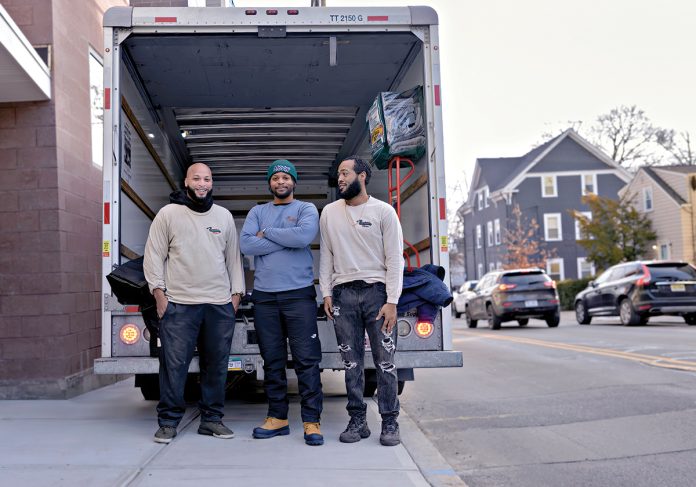 SUPPORT SYSTEM: Trent Manning, center, is the founder and owner of Down The Road Movers LLC, a Black-owned moving company that he launched to support formerly incarcerated individuals. Pictured with Manning, from left, are foremen/drivers Genesis Harney and Ryan Fogarty. PBN PHOTO/MICHAEL SALERNO