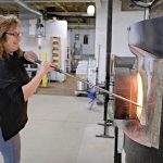 COOL UNDER FIRE: Rebecca Zhukov, co-owner of Blackstone River Glass Center LLC in Cumberland, works with the furnace at the glass studio, which she started with her business partner about six years ago.  PBN PHOTO/ MICHAEL SALERNO