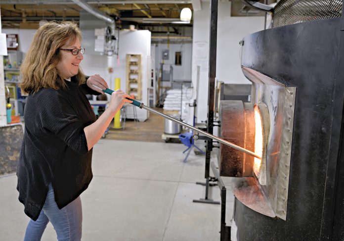 COOL UNDER FIRE: Rebecca Zhukov, co-owner of Blackstone River Glass Center LLC in Cumberland, works with the furnace at the glass studio, which she started with her business partner about six years ago.
PBN PHOTO/
MICHAEL SALERNO COOL UNDER FIRE: Rebecca Zhukov, co-owner of Blackstone River Glass Center LLC in Cumberland, works with the furnace at the glass studio, which she started with her business partner about six years ago.
PBN PHOTO/
MICHAEL SALERNO