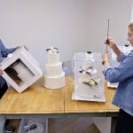 STURDY PROTECTION: CakeSafe LLC co-owners Scott and Juli Chapin with some of their wedding cake transport boxes, which can keep cakes in place even when tipped on their side. PBN PHOTO/MICHAEL SALERNO