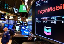 OIL COMPANY logos are displayed on the floor of the New York Stock Exchange on March 3. Gas prices in the Ocean State have increased 27 cents from a week ago to $3.15 per gallon, according to AAA Northeast. / AP PHOTO/SETH WENIG