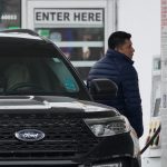 A PERSON fills up his vehicle's gas tank in Glenview, Ill. The average weekly price of self-serve, regular unleaded gasoline in Rhode Island is up 17 cents from last week, reaching $3.04 per gallon, AAA Northeast said Wednesday. / AP PHOTO/NAM Y. HUH