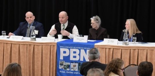 DR. CHRISTOPHER OTTIANO, second from left, interim chief medical officer and medical director at Neighborhood Health Plan of Rhode Island, speaks during one of two panel discussions during Providence Business News' Health Care Summit at Marriott Providence on Thursday. Also on the panel are, from left, Joseph Trunzo, associate director of Bryant University's School of Health and Behavioral Sciences; Linda Hurley, CODAC Inc. CEO and president; and Meghan Grady, Meals on Wheels of RI Inc. executive director. / PBN PHOTO/MIKE SKORSKI