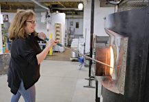 COOL UNDER FIRE: Rebecca Zhukov, co-owner of Blackstone River Glass Center LLC in Cumberland, works with the furnace at the glass studio, which she started with her business partner about six years ago.  PBN FILE PHOTO/MICHAEL SALERNO