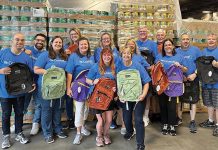 WELL-SUPPLIED: As part of Coast1 Credit Union’s annual Back to School Celebration, employees distribute free backpacks to children. COURTESY COASTAL1 CREDIT UNION