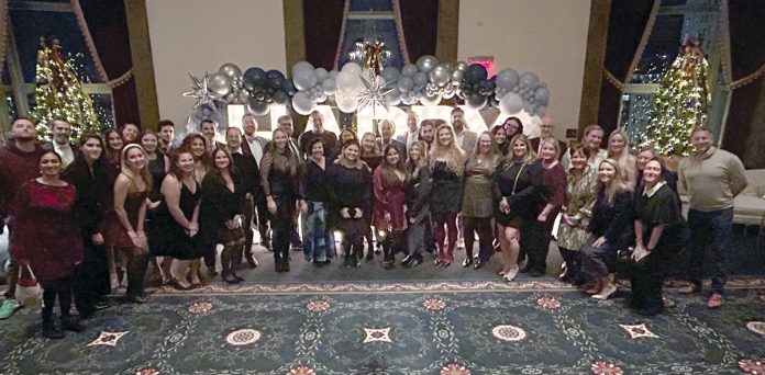 DECKING THE HALL: DarrowEverett LLP employees turn out for the company holiday party.  COURTESY DARROWEVERETT LLP