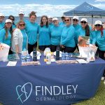 Safety in the sun: Findley employees staff a table providing skincare products at a local beach.  COURTESY FINDLEY DERMATOLOGY LLC