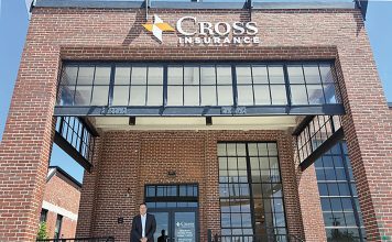 NEW WORKSPACE: Peter Gillespie, senior vice president and branch manager for Cross Insurance Inc., stands at the entrance of the company’s new offices at The Foundry in Providence.  PBN PHOTO/MATTHEW MCNULTY
