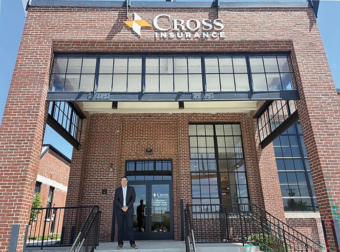 NEW WORKSPACE: Peter Gillespie, senior vice president and branch manager for Cross Insurance Inc., stands at the entrance of the company’s new offices at The Foundry in Providence.  PBN PHOTO/MATTHEW MCNULTY