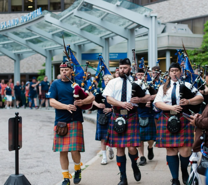 TARTAN ARMY bagpipe players lead the way past Rhode Island Hospital as Scottish soccer supporters stop at Hasbro Children's Hospital on June 18 to make a $10,000 donation. / COURTESY BROWN UNIVERSITY HEALTH