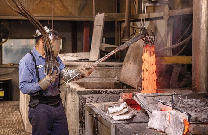 RED HOT: Heat treater Juan Smith treats pieces of steel at Metallurgical Solutions Inc. in Providence. The company uses controlled heating and cooling processes to change the internal properties of steel to strengthen it and send it back to customers for various applications. PBN PHOTO/TRACY JENKINS