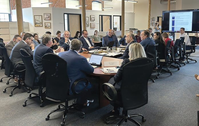 FULL HOUSE: Gov. Daniel J. McKee, third from the left, leads a June meeting of the R.I. Commerce Corp. board, whose 12 members are appointed by the governor.  COURTESY R.I. ­COMMERCE CORP.
