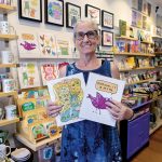 JOYFUL SURVIVAL: Kim T. Clark shows off some of the wares in her Rhody Craft gift shop in Providence, which she started as a pop-up in 2008 to support her children after she was treated for cancer and while going through a divorce.  PBN PHOTO/MICHAEL SALERNO
