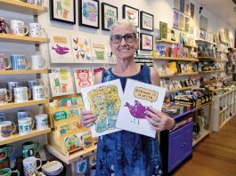 JOYFUL SURVIVAL: Kim T. Clark shows off some of the wares in her Rhody Craft gift shop in Providence, which she started as a pop-up in 2008 to support her children after she was treated for cancer and while going through a divorce.  PBN PHOTO/MICHAEL SALERNO