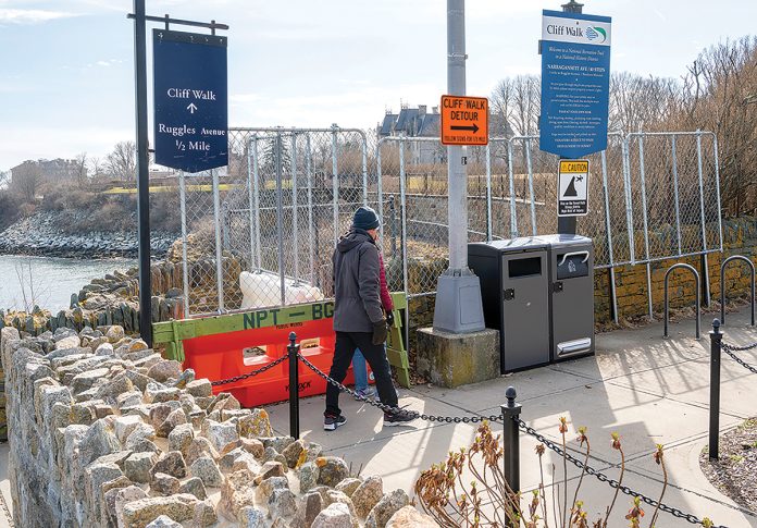 MORE OF THE SAME: Walkers heading south on the Newport Cliff Walk in 2023 are stopped at Narragansett Avenue by fencing because part of the historic walk collapsed in 2022. Little has changed since then. PBN FILE PHOTO/DAVID HANSEN