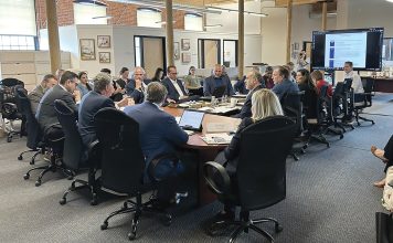 IN GOOD COMPANY: The R.I. Commerce Corp. board meets at Cumberland-based baby product company Baby Delight Inc. in June for a strategic retreat to discuss economic and workforce trends. Gov. Daniel J. McKee, third from the left, leads the meeting.  COURTESY R.I. COMMERCE CORP.