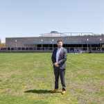 R.I. PUBLIC TRANSIT AUTHORITY CEO Christopher Durand stands in a field in front of the Providence train station, one of two parcels that was being considered in 2025 for a new central transit hub. The project has has been awarded $25 million in federal money, according to the Rhode Island congressional delegation. / PBN FILE PHOTO/TRACY JENKINS