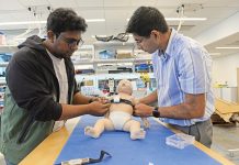 TEST BED: ­Abdullah al Rumon, left, and Dr. Kunal Mankodiya, director of the Wearable Biosensing Lab at the University of Rhode Island, are part of a team developing a smart strap that can monitor the health condition of premature babies. PBN PHOTO/­ELIZABETH ­GRAHAM