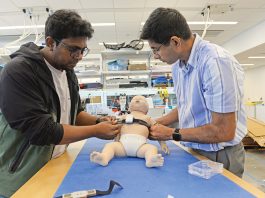 TEST BED: ­Abdullah al Rumon, left, and Dr. Kunal Mankodiya, director of the Wearable Biosensing Lab at the University of Rhode Island, are part of a team developing a smart strap that can monitor the health condition of premature babies. PBN PHOTO/­ELIZABETH ­GRAHAM