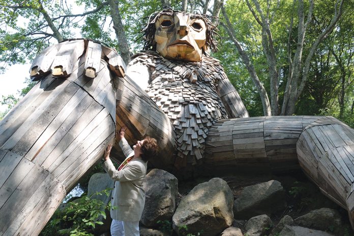 TROLL ­SIGHTING: ­ Louise Bishop, South County Tourism Council CEO and president, visits one of the two trolls living in the woods of Ninigret Park in Charlestown. Bishop says the trolls, made of recycled materials, have drawn 100,000 visitors this year alone. Three more trolls have been installed recently in Rhode Island.  PBN FILE PHOTO/­ELIZABETH GRAHAM