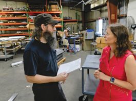 SHINING BRIGHT:  Rich Reynolds, left, fabrication supervisor, speaks with Jessica Mularski, majority owner, at Renova Lighting Systems Inc. in Warwick. PBN PHOTO/­MICHAEL SALERNO