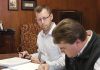 NEXT GEN: Chaffee Industrial Roofing President Peter Chaffee, foreground, officially marks the fourth generation of family ownership in 2019, signing paperwork transferring ownership in the presence of an unidentified lawyer.  COURTESY CHAFFEE INDUSTRIAL ROOFING