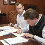 NEXT GEN: Chaffee Industrial Roofing President Peter Chaffee, foreground, officially marks the fourth generation of family ownership in 2019, signing paperwork transferring ownership in the presence of an unidentified lawyer.  COURTESY CHAFFEE INDUSTRIAL ROOFING